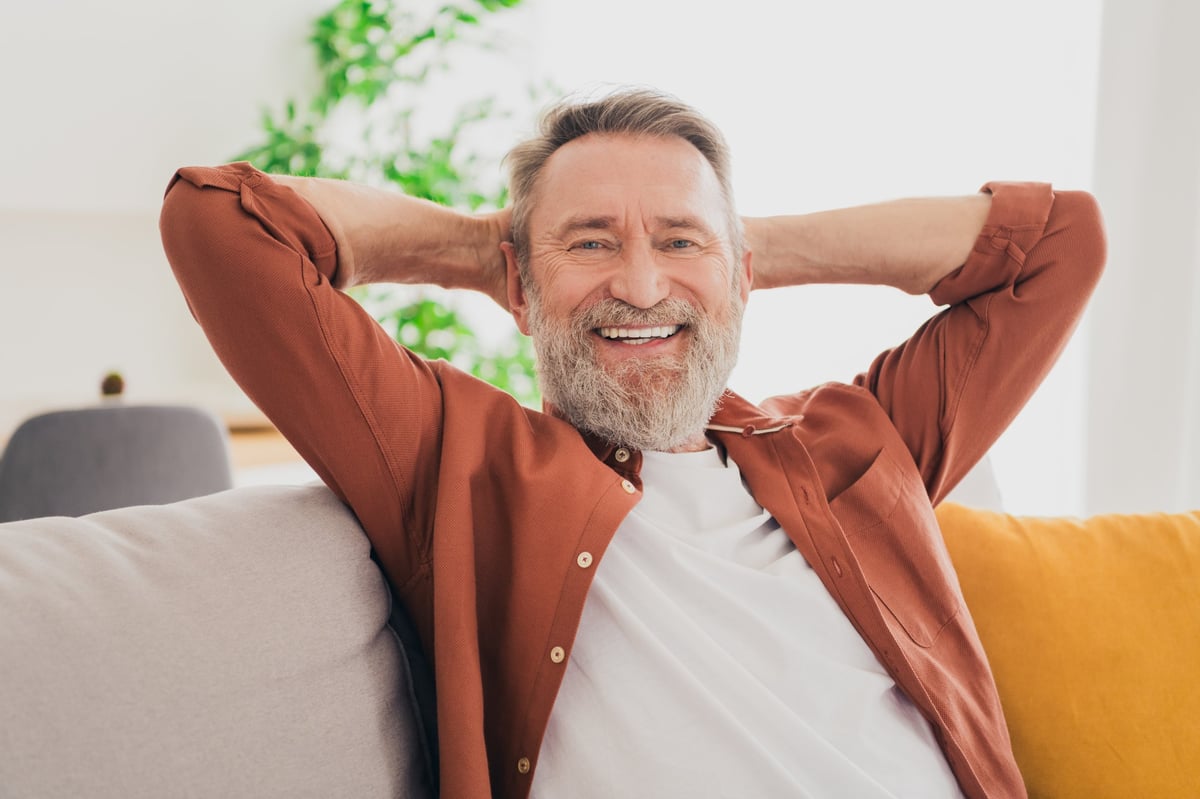 Senior man relaxing comfortably on his couch in his own home